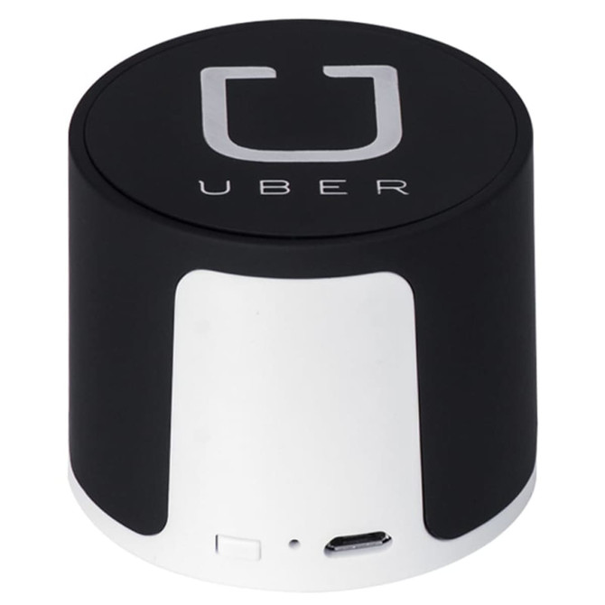 A wireless speaker in black and silver, featuring a logo. Compact design with a USB port.