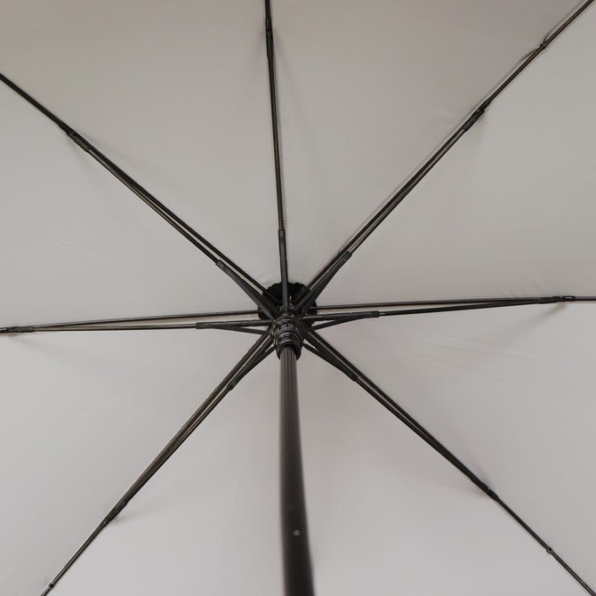 An open umbrella viewed from underneath, featuring a black rib structure and a white canopy.
