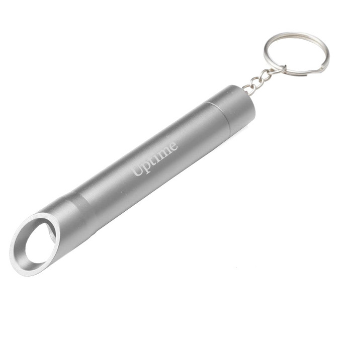 A silver drink bottle opener keychain with a cylindrical design and circular opening. The keychain has a branding logo.