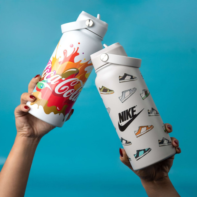 A drink bottle in white featuring sneaker graphics and a colourful design, with a flip-top lid and a logo.