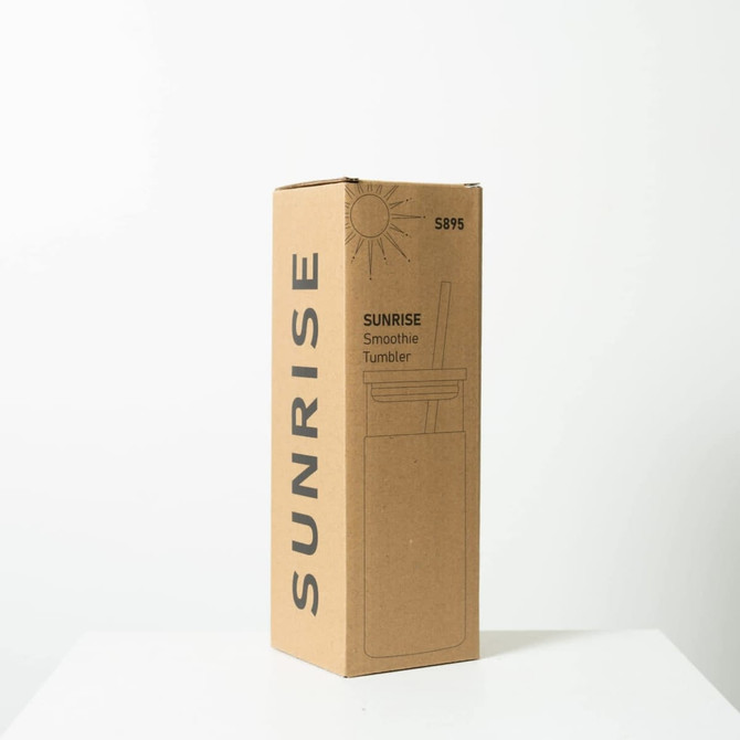 A drink bottle in a cardboard box, featuring a design for the Sunrise Smoothie 500mL Tumbler in neutral colours.