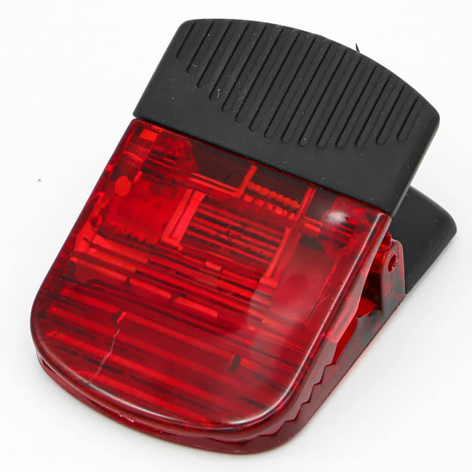 A red magnetic clip with a black top, featuring a textured surface for grip and a logo on the body.