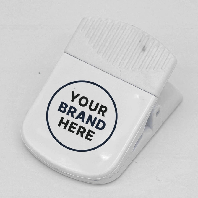 A white magnetic clip with a textured grip and a circular logo area. Suitable for office use.