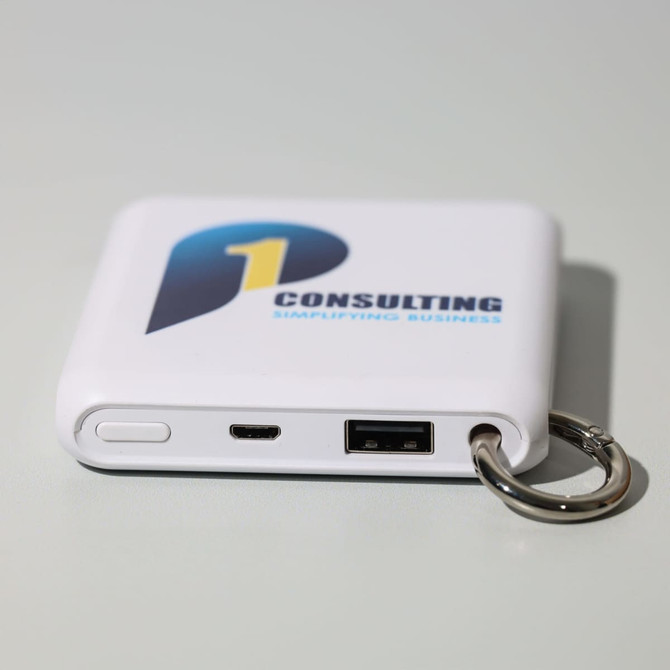 A white power bank with a keyring attachment, featuring USB and micro USB ports and a logo.