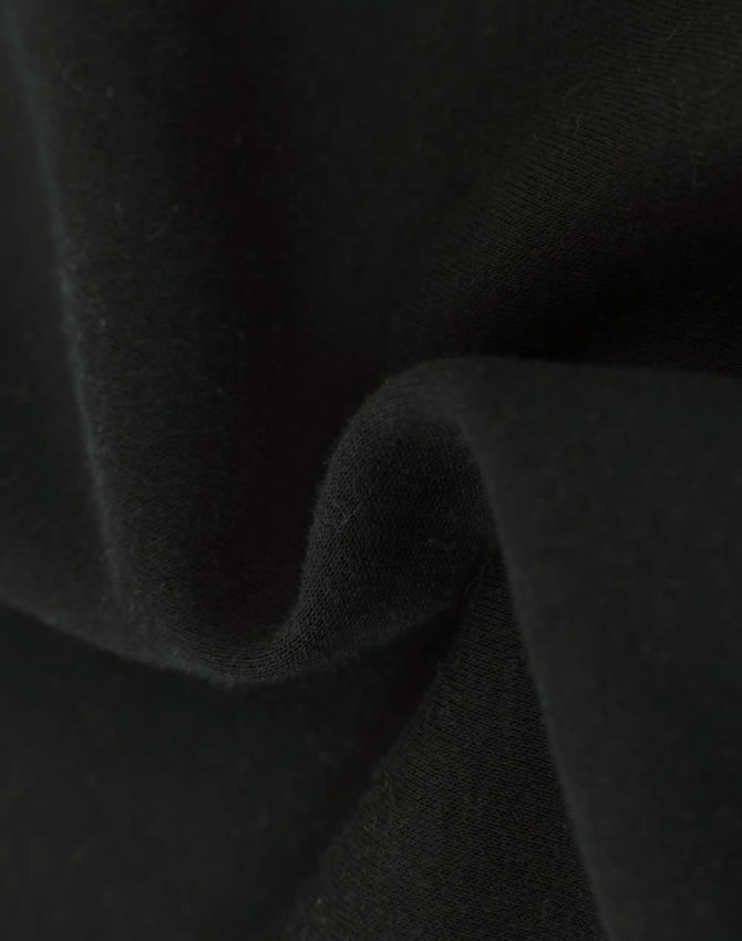 A close-up of soft, black fabric showcasing a textured surface, indicating a fleece material.