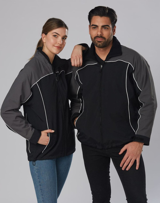 A black and grey reversible jacket featuring a logo, modelled by a man and a woman.