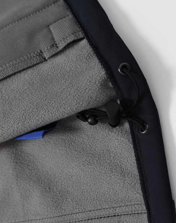 A close-up of the interior lining of a navy men's softshell full zip hoodie, featuring a drawstring and a pocket.