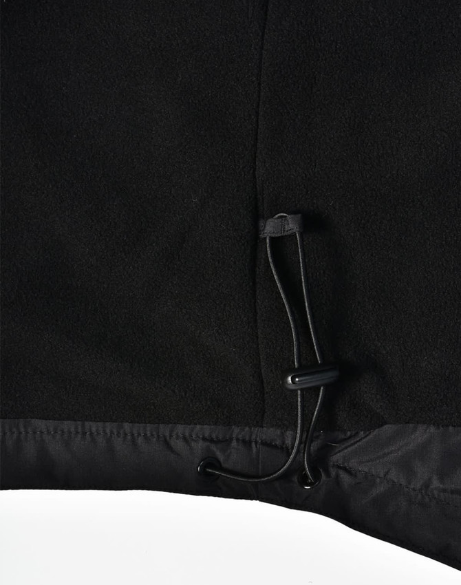 A close-up of the bottom hem of a black unisex jacket featuring a drawstring adjustment.