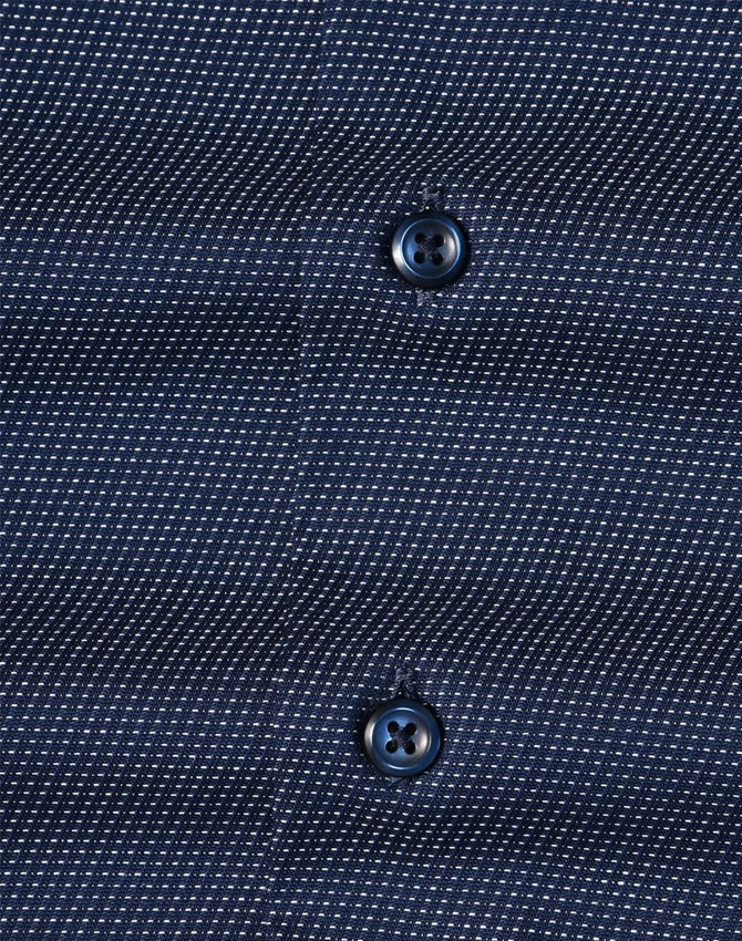 Men's long-sleeve button-up shirt in navy with a pin dot pattern and two dark buttons. Features subtle texture.