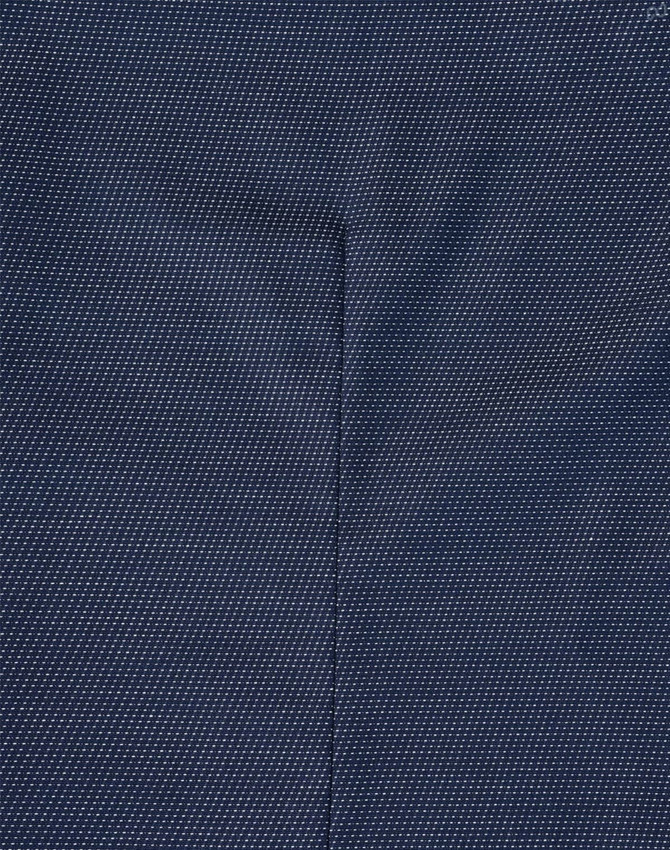A close-up of a navy blue fabric with a pin dot pattern, showcasing the texture of the shirt.