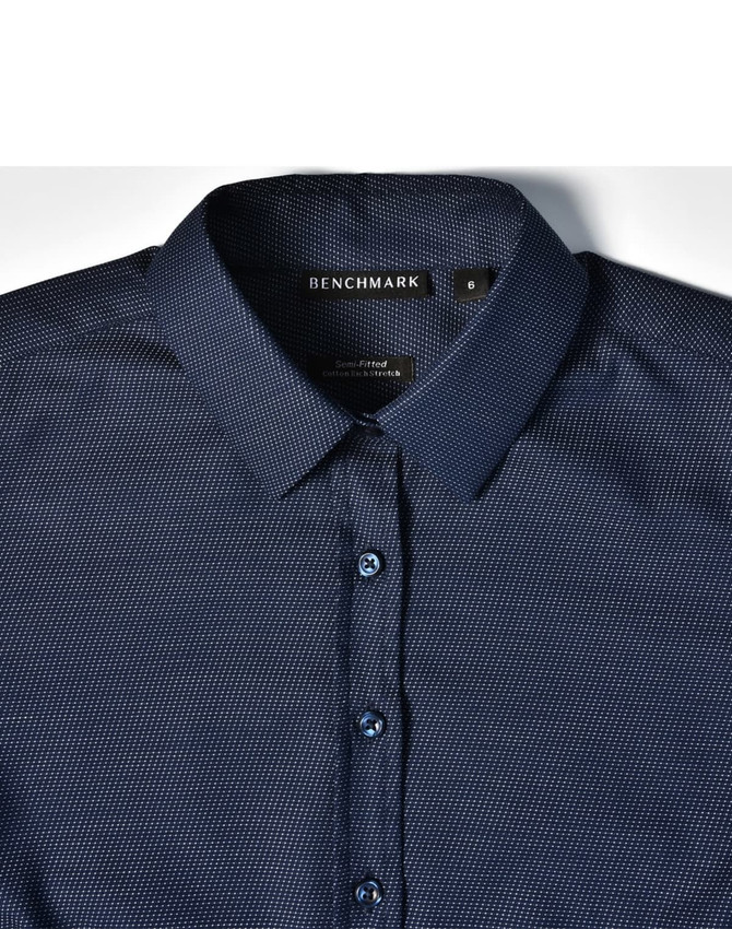 A navy blue pin dot stretch long sleeve shirt with a button-up collar and logo branding on the label.