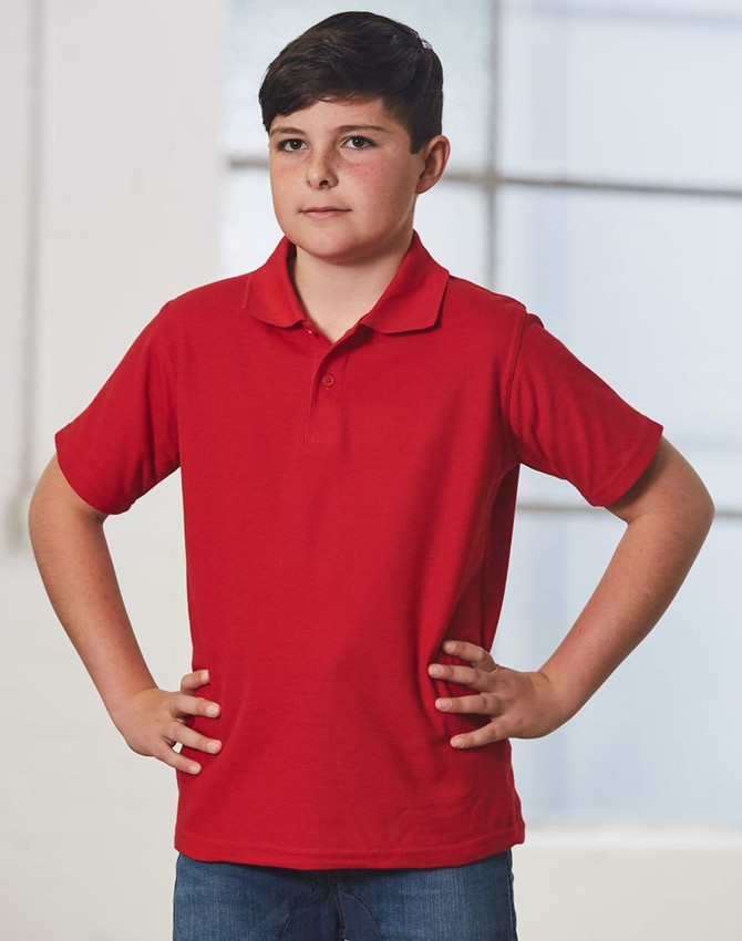 A red children's traditional polo shirt displayed on a model, featuring a classic collar and short sleeves.