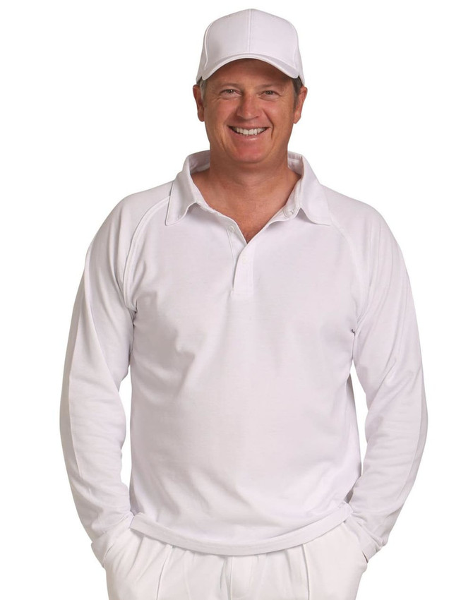 A long-sleeved white cricket polo shirt displayed on a smiling man wearing a matching white cap.