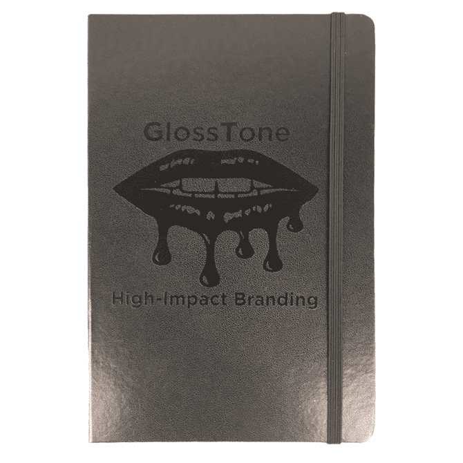 A black journal with an elastic band and a logo on the cover, featuring a glossy finish.