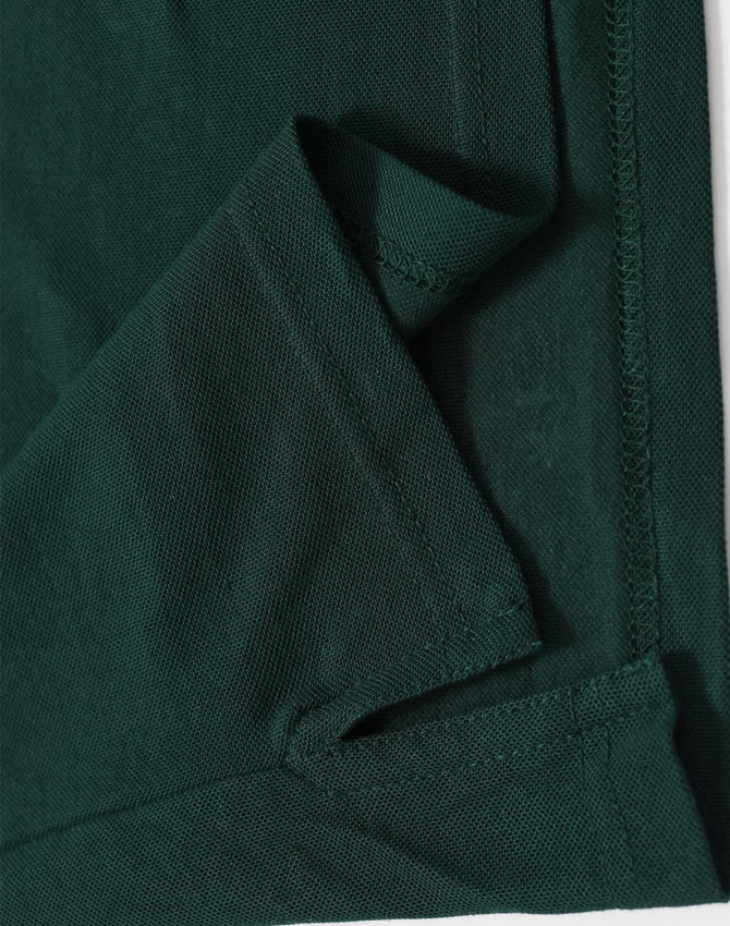 A dark green men's polo shirt featuring a folded hem and stitching details, including a logo.