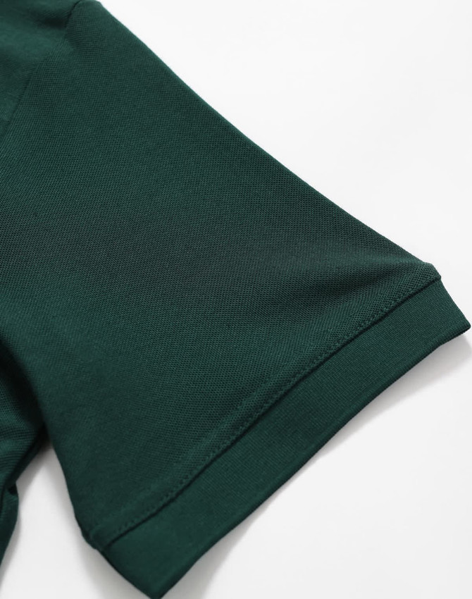 A close-up of a dark green polo shirt sleeve featuring a logo. The fabric appears smooth and lightweight.