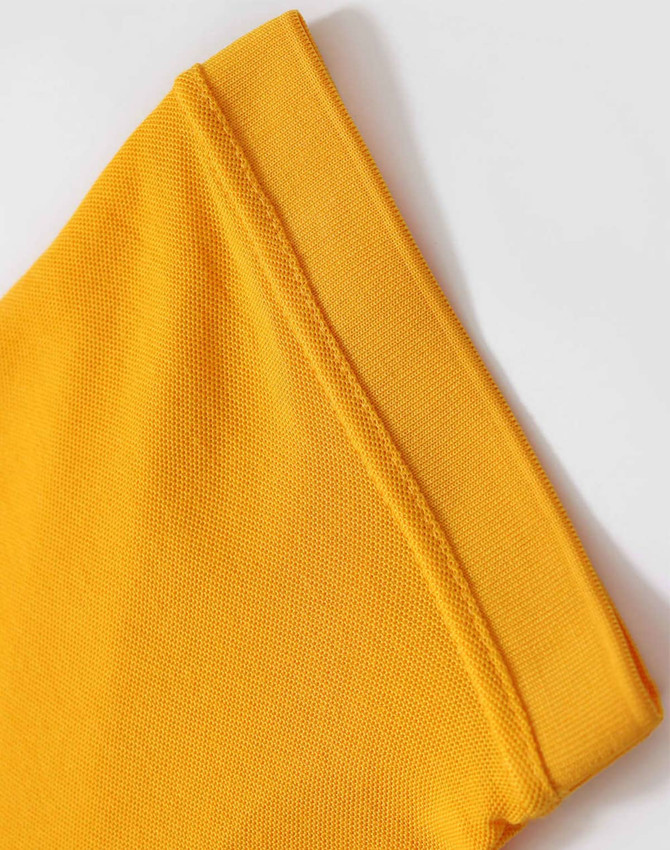 A close-up of a folded yellow polo shirt sleeve with a textured fabric detail. The shirt features a logo.
