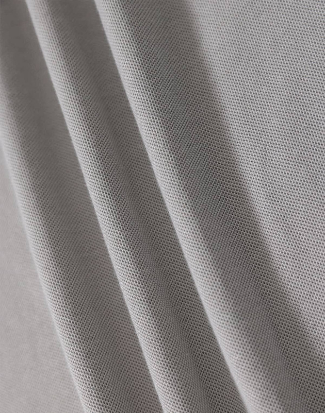 A textured fabric in light grey, showcasing a breathable mesh design suitable for polo shirts.