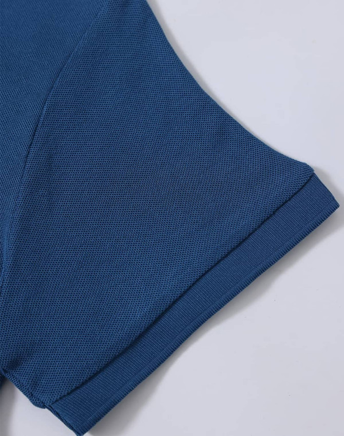 A close-up of a blue polo shirt sleeve, showcasing the textured fabric and stitched details. The shirt has a logo.
