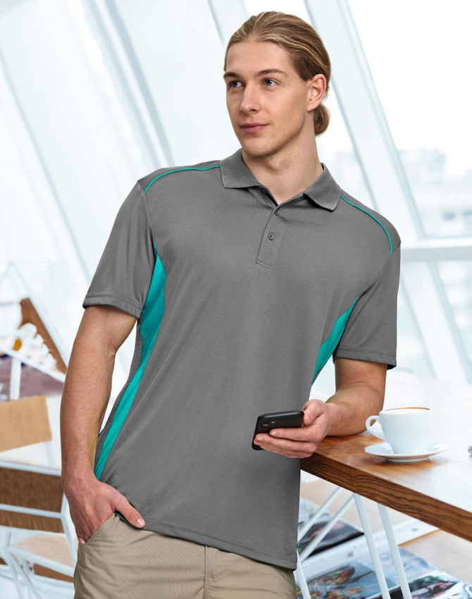A dark green polo shirt with bright green accents and a logo, worn by a man standing indoors.