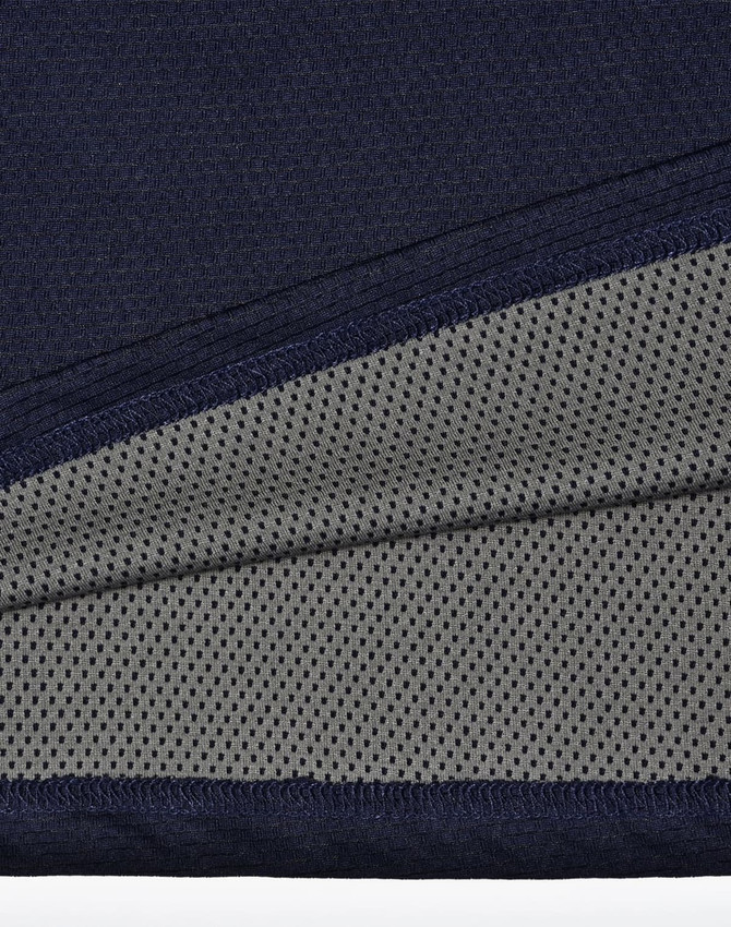 A close-up of a navy polo shirt detailing with a grey mesh inner lining, featuring a logo.