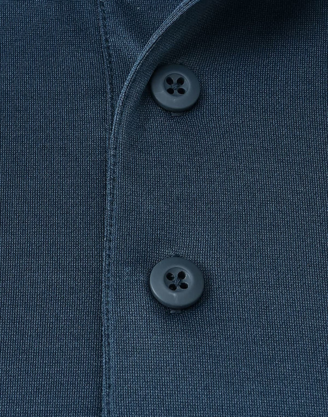 Close-up of a navy blue poly/cotton polo shirt featuring two buttons and a textured fabric. Includes a logo.