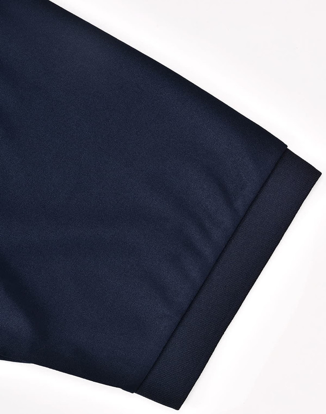 A navy blue men's sustainable poly/cotton polo shirt showcasing the cuff detail with a logo.