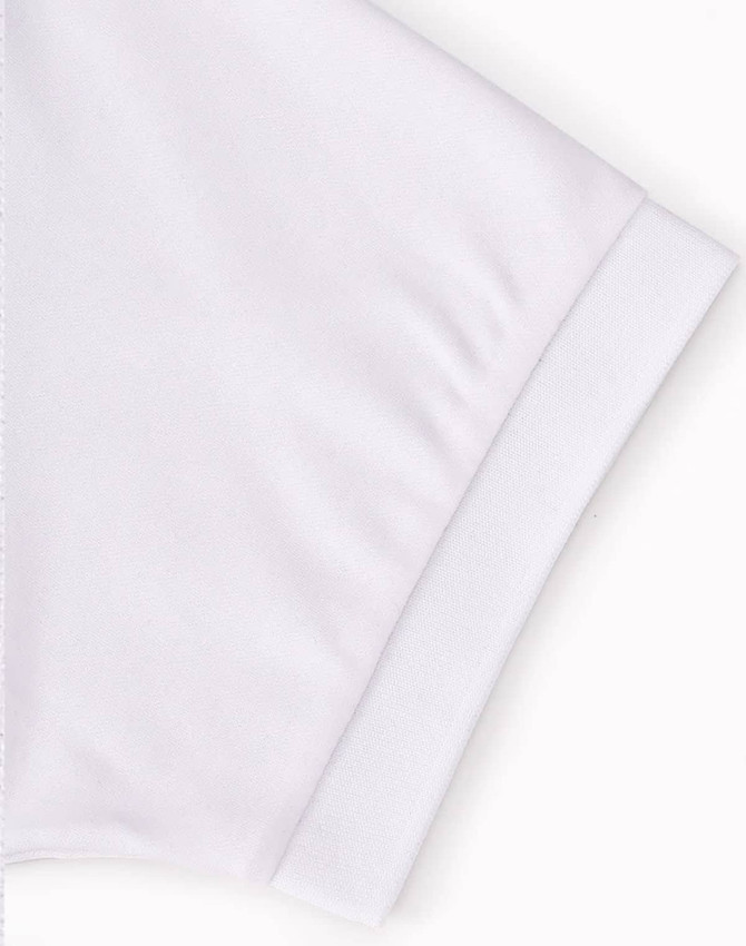 A white polo shirt featuring a fold-over collar and cuff, with a logo on the sleeve.