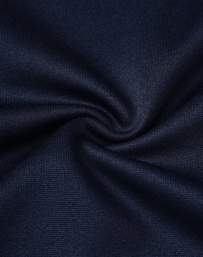 A close-up of textured navy fabric, showcasing the sustainable poly/cotton blend used in kids' polo shirts.