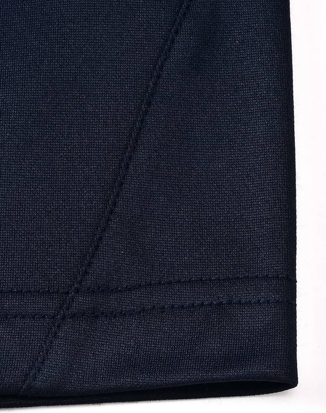 A close-up view of a navy polo shirt sleeve featuring a contrasting seam and stitching detail.