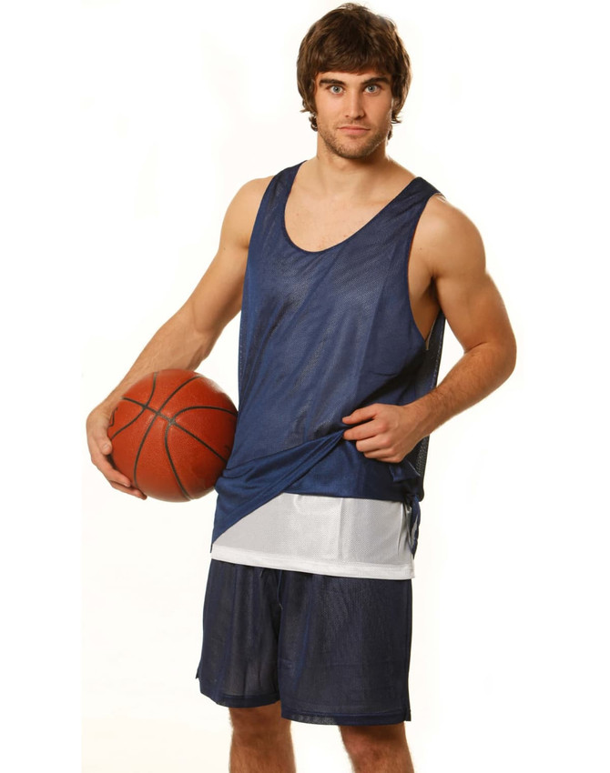 A man in navy blue basketball shorts and a matching jersey holds a basketball, featuring a logo on the jersey.
