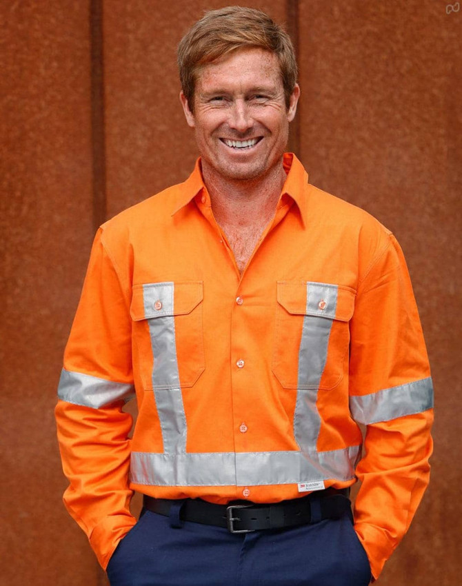 A bright orange long-sleeve drill shirt with reflective 3M tape and two chest pockets. The shirt features a logo.