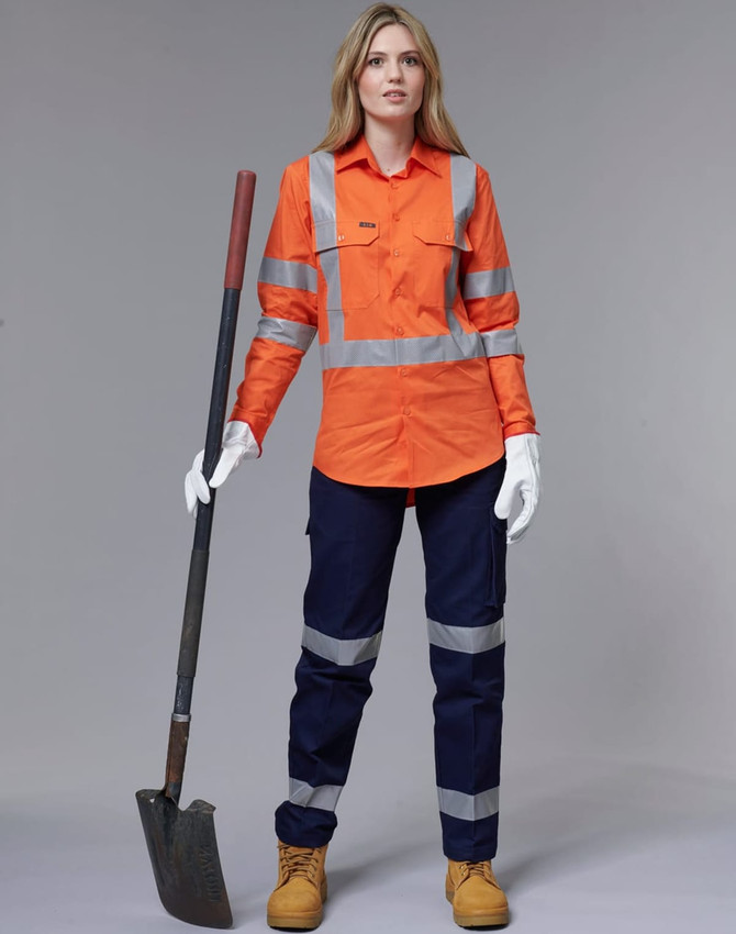 An orange work shirt with reflective stripes, paired with navy pants and work boots, held by a woman with a shovel.