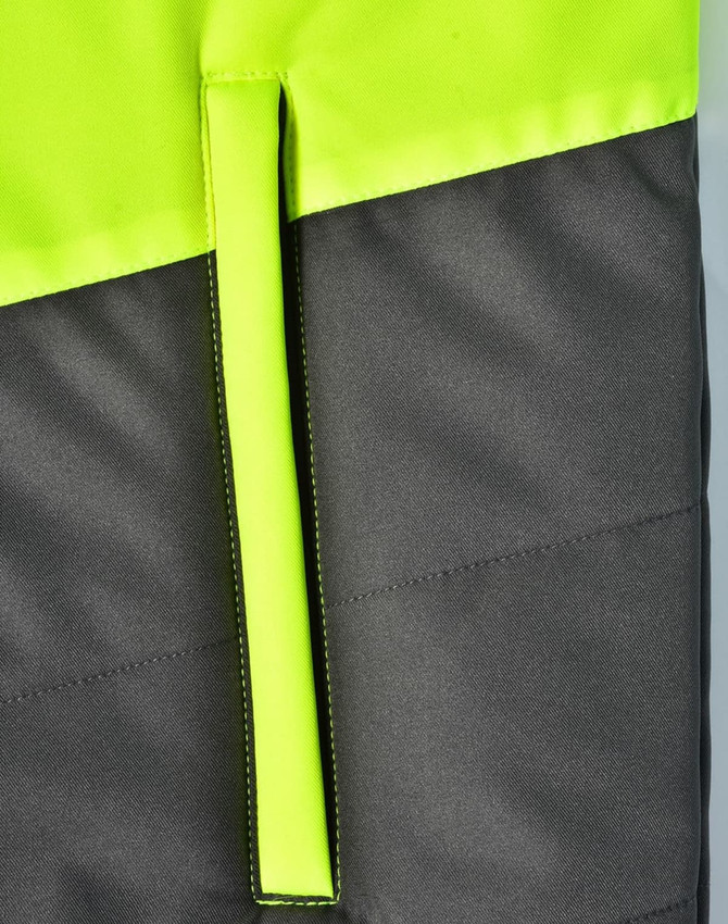 A hi-vis quilted safety jacket featuring a bright yellow upper and dark grey lower section, with a hanger loop.