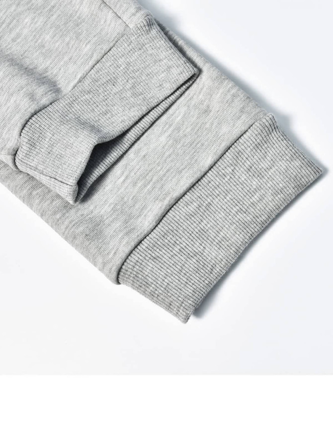 A close-up of grey poly/cotton terry sweat pant cuffs featuring ribbed texture and stitching details.