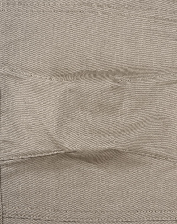 A close-up of unisex cotton stretch ripstop work pants in a light beige colour, featuring a stitched waistband and branding.