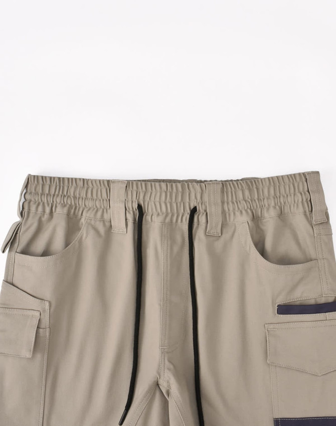 Unisex cotton stretch drill short work shorts in beige with an elastic waistband and multiple pockets.