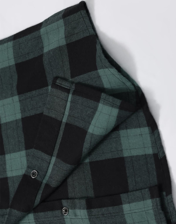 A unisex flannel plaid shirt featuring green and black check patterns, with button-up details and a logo.