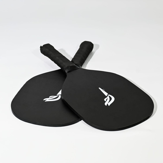 A pair of black pickleball paddles with textured handles, featuring a logo on each paddle.