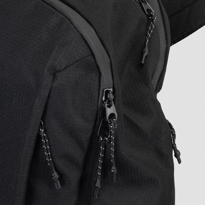 A black business computer backpack featuring zippers with black and white pull cords.
