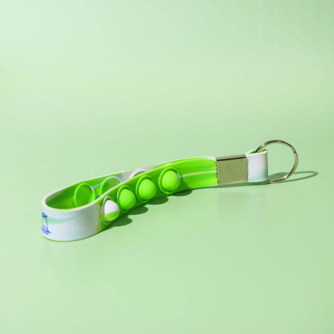 A green and white Popper Stress Reliever Key Chain featuring several poppable buttons and a metal keyring attachment.