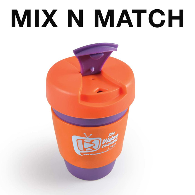 A reusable coffee cup in orange and purple with a silicone band and a cap. It features a logo.