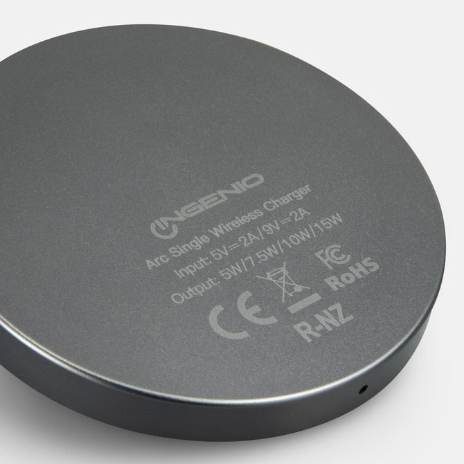 A circular grey wireless charger with a logo and output specifications on the base.