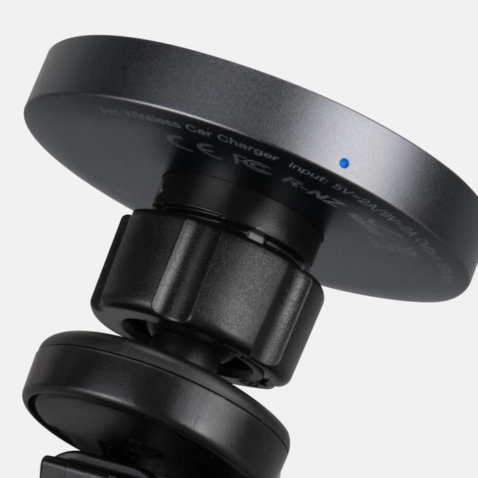 A wireless car charger in black with a round charging pad and an adjustable mount. It features a small blue indicator light.