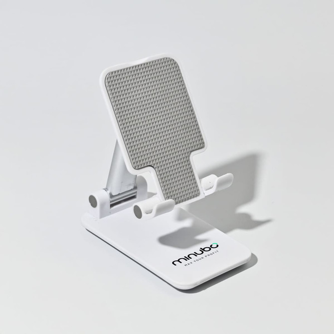A white folding desktop mobile phone and tablet stand with a textured grey surface. It features a logo on the base.