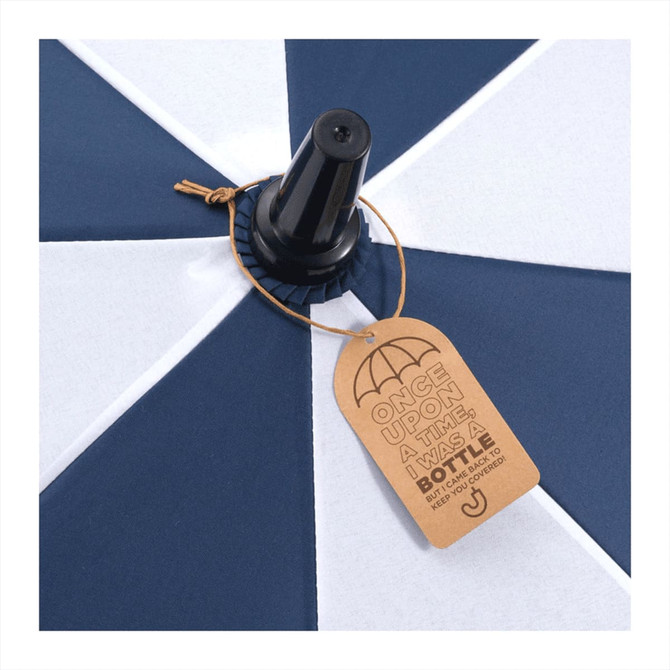 A navy and white recycled golf umbrella with a black handle and a tag attached.