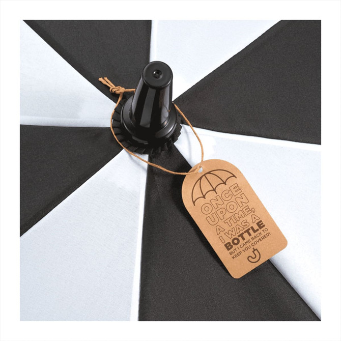 A black and white golf umbrella with a central pole and a tag attached, featuring a logo.