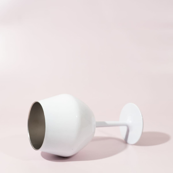 A white Shiraz detachable wine glass featuring a sleek design, displayed on a soft pink background.