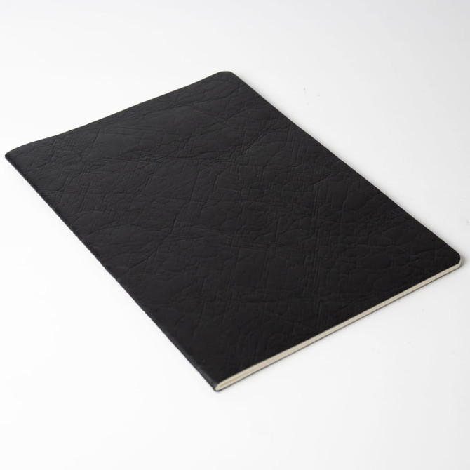 A black notebook with a textured cover, open with white pages visible. It has a simple, sleek design and no branding.