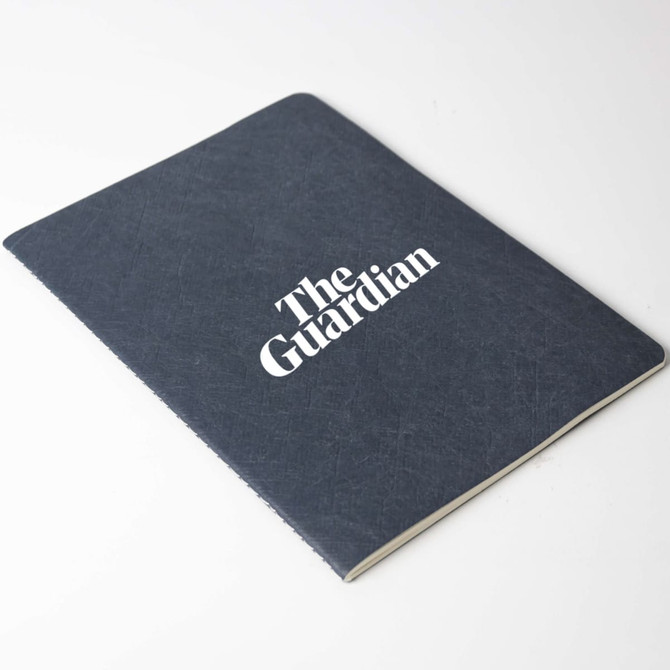 A navy blue A5 notebook with a textured cover, featuring a logo on the front.